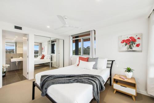 een witte slaapkamer met een bed en een badkamer bij Jamieson Apartments Reid ACT in Canberra