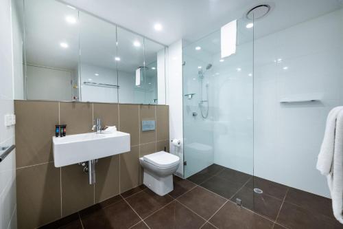 een badkamer met een wastafel, een toilet en een douche bij Jamieson Apartments Reid ACT in Canberra