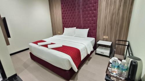 a bedroom with a large bed with a red headboard at The Corum View Hotel in Bayan Lepas