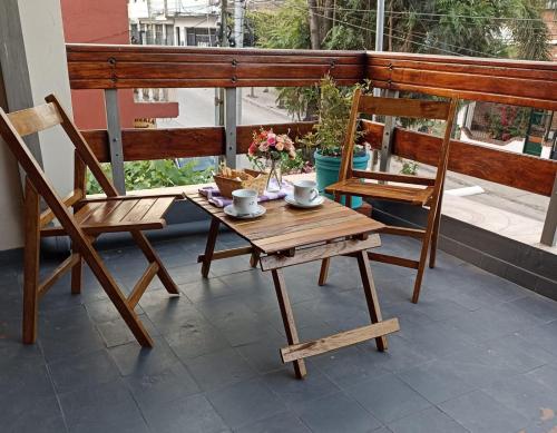 a wooden table and two chairs on a balcony at Los Jazmines in San Salvador de Jujuy