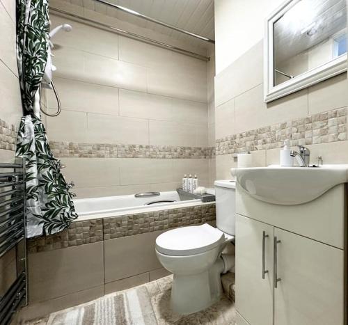 的住宿－Joyful Jungle Jewel w/Balcony & Foozeball-Ferndale，浴室配有卫生间、盥洗盆和浴缸。