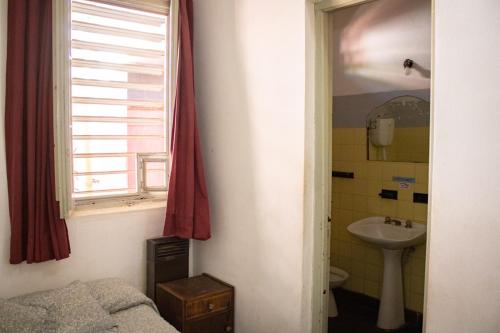 La salle de bains est pourvue d'un lit, d'un lavabo et d'une fenêtre. dans l'établissement El Viaje Hostel, à Mina Clavero