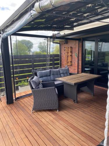 a wooden deck with a couch and a table at peaceful and rural escape 