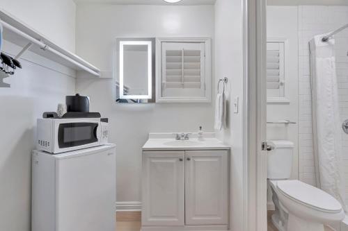 a white bathroom with a toilet and a microwave at Santa Monica Hotel in Los Angeles