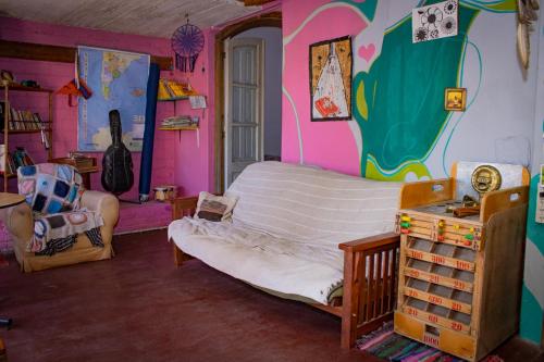 1 dormitorio con 1 cama grande en una habitación con una pared pintada en El Viaje Hostel en Mina Clavero