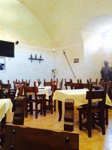 a room with tables and chairs and a man standing in a room at Castello Conti Filo in Torre Santa Susanna