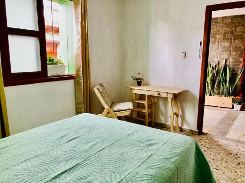 a bedroom with a bed and a desk and a table at Alhambra Hotel - San Cristóbal de las Casas in San Cristóbal de Las Casas