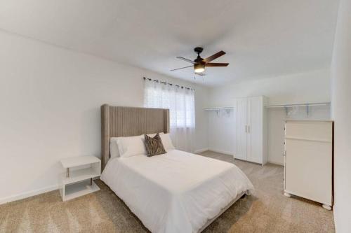 a white bedroom with a bed and a ceiling fan at Elegante casa cerca de Galleria Mall, NRG, Centro Medico! in Houston