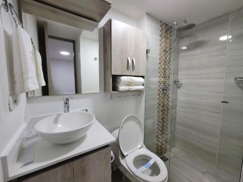 La salle de bains est pourvue de toilettes, d'un lavabo et d'une douche. dans l'établissement Modern 2/2 Apartment in Sabaneta with City View, à Sabaneta