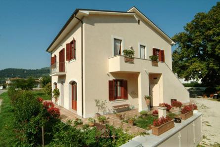a small white house with potted plants on it at Agriturismo Casa Mattei in Arrone