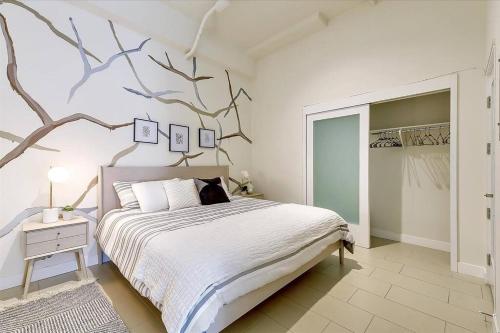 a bedroom with a bed with a tree mural on the wall at Luxury downtown loft 1 bedroom in Los Angeles