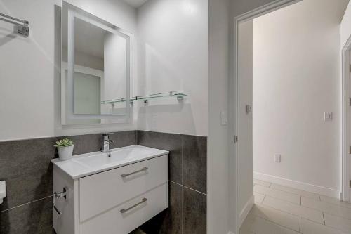 a white bathroom with a sink and a mirror at Luxury downtown loft 1 bedroom in Los Angeles