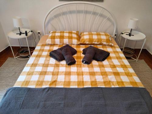 a bed with two pillows on it with two tables at Casa d´Avó in Fiais da Telha