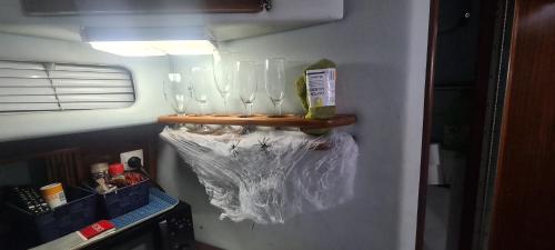 a shelf with wine glasses on a wall at Boat to sleep in Barcelona in Barcelona