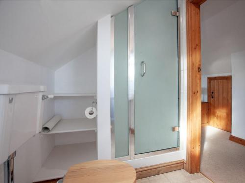 a bathroom with a glass shower and a table at Smugglers Retreat in Hartland