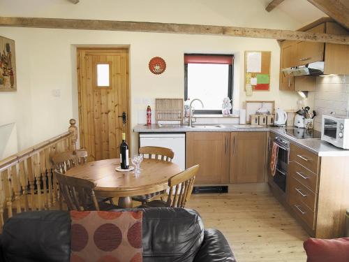 a kitchen with a wooden table and a dining room at Skellgill Barn in Bainbridge