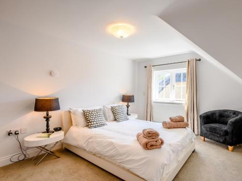 1 dormitorio con 1 cama con toallas en Hambury House en West Lulworth