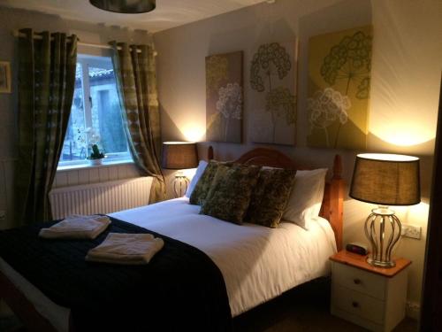 a bedroom with a bed with two towels on it at Sleepy Fox Cottage in Levisham