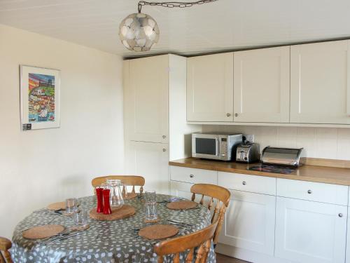 a kitchen with a table with chairs and a microwave at Sunnyside in Sandsend