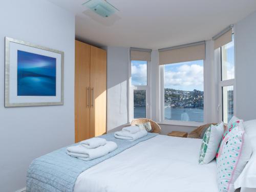a bedroom with a large bed with towels on it at Apartment 2 The Wheelhouse in Fowey