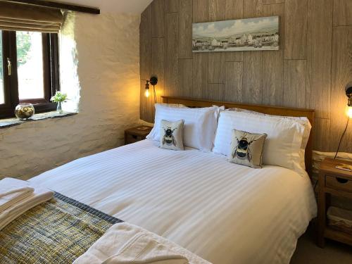a bedroom with a large white bed with two dogs pillows at Cider Press Cottage in Fowey