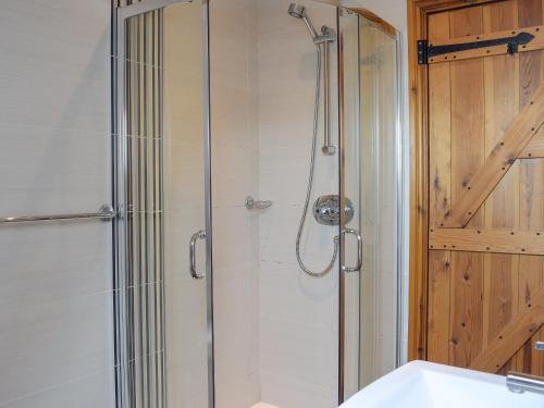 a shower with a glass door in a bathroom at Captains Cottage - E3643 in Whitby