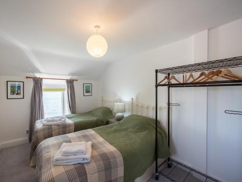 a bedroom with two beds and a bunk bed at Blue Sails-jpv in Llangoed