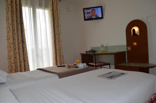 a bedroom with a bed and a table with a plate on it at Hostellerie Saint Vincent Beauvais Aeroport in Beauvais
