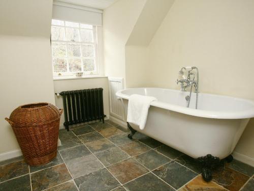a white bath tub in a bathroom with a window at Find Me Out - Sccw in Dalmellington