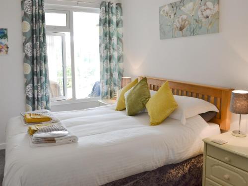 1 dormitorio con 1 cama blanca grande y ventana en Bosorne, en Newlyn