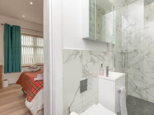 a bathroom with a shower and a bed in a room at Inverspey in Kingston