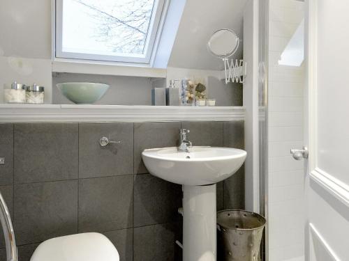 a bathroom with a sink and a toilet and a window at The Indie House in Crieff