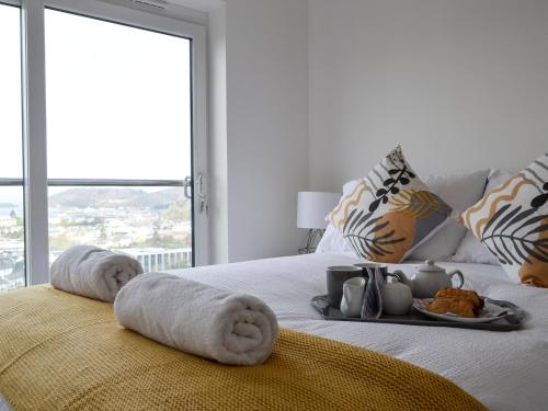 a white bed with towels and a tray of food on it at Sealladh Alainn in Oban