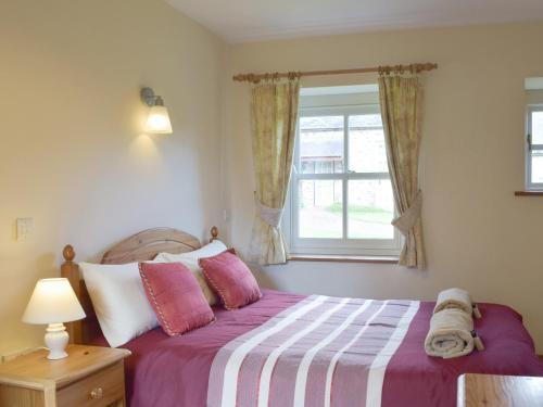 a bedroom with a bed and a window at Cothi Cottage in Llanfynydd