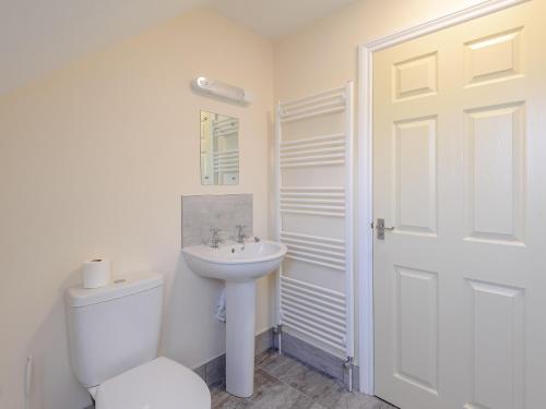 a white bathroom with a toilet and a sink at Dawson Park 4 - Uk12663 in Mablethorpe