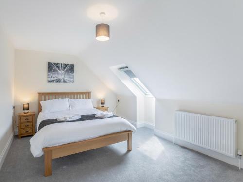 a white bedroom with a bed and a staircase at Dawson Park 10 - Uk12669 in Mablethorpe