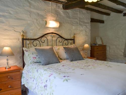 una camera con un grande letto e due lampade di Ceunant a Aber Cowarch