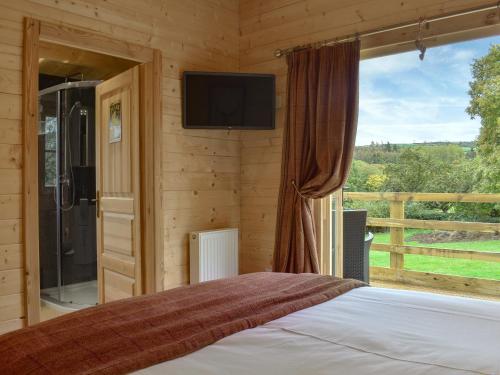 a bedroom with a bed and a tv and a window at Brook Cottage - Uk12643 in Sleights
