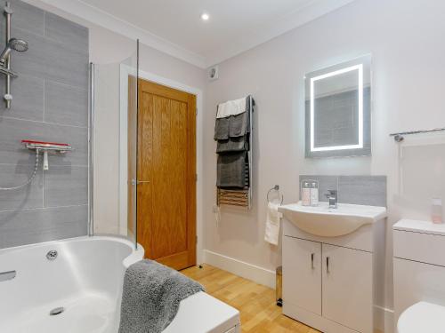 a bathroom with a white tub and a sink at Steyning Kilns in Steyning