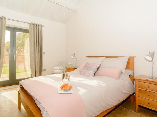 a bedroom with a bed with a tray of fruit on it at Bluebell Barn - Uk12792 in Royal Wootton Bassett