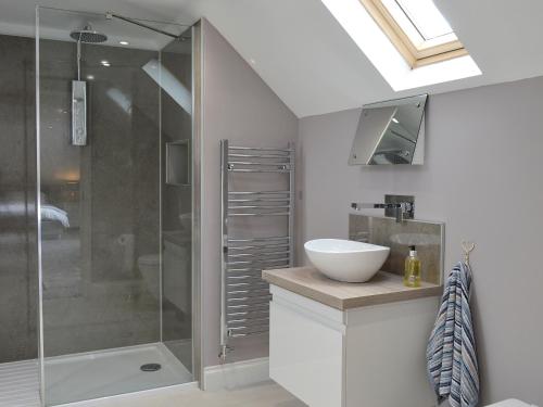 a bathroom with a glass shower and a sink at Torcross Barn in Tarbolton