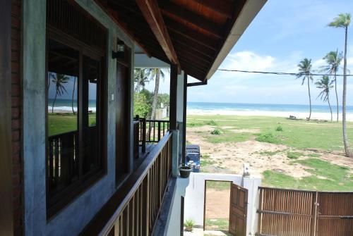 a porch of a house with a view of the beach at Lion's Rest in Weligama