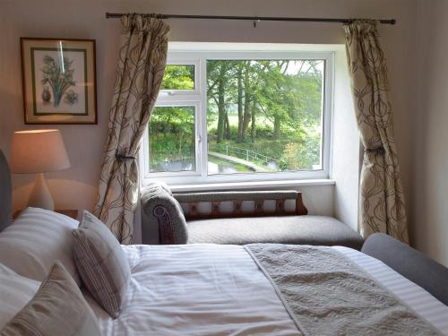 a bedroom with a bed and a large window at The Farmhouse - Uk13183 in Cwm-Morgan