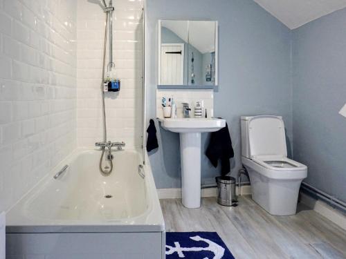 a bathroom with a tub and a sink and a toilet at Honeysuckle Cottage in Watchet