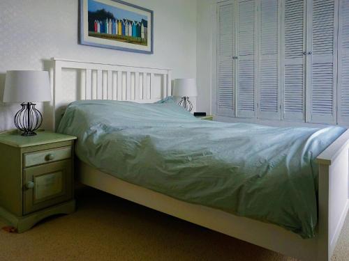 1 dormitorio con 1 cama y 2 lámparas en las mesas en Honeysuckle Cottage, en Watchet