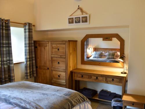 a bedroom with a large mirror and a bed at Gelderslack Barn in Nateby