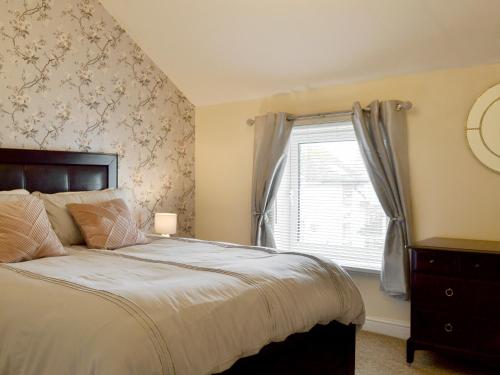 a bedroom with a large bed and a window at Seagulls Rest in Filey