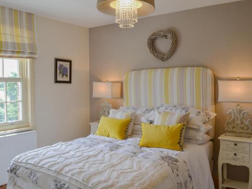 a bedroom with a large bed with yellow pillows at Farrington House in Lowthorpe