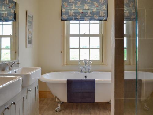 a bathroom with a tub and two sinks and a shower at Farrington House in Lowthorpe