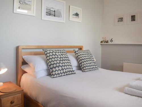 Un dormitorio con una cama blanca con almohadas. en Apartment 6 harlech en Criccieth